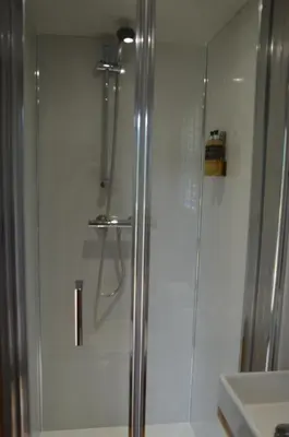 a shower with a glass door in a bathroom at Corriemuckloch Unique Huts in Dunkeld