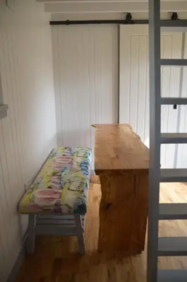a bench in a room with a wooden table at Corriemuckloch Unique Huts in Dunkeld