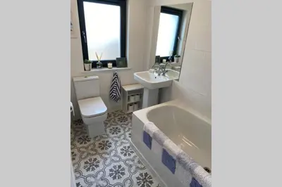 a bathroom with a tub and a sink and a toilet at 2x King Bedrooms, private living room & bathroom in Thornhill