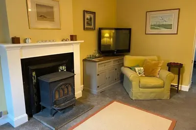 a living room with a fireplace and a tv and a chair at 2x King Bedrooms, private living room & bathroom in Thornhill