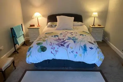 a bedroom with a bed with a floral bedspread at 2x King Bedrooms, private living room & bathroom in Thornhill