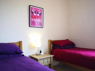 a room with two beds and a table and a picture at Forth View Apartment in Stirling