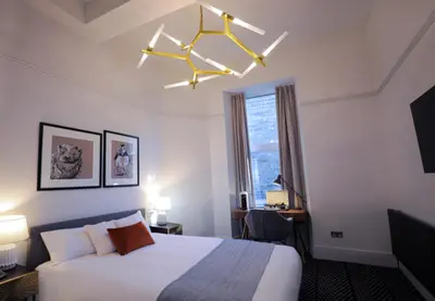 a hotel room with a bed and a chandelier at Boutique 50 in Glasgow