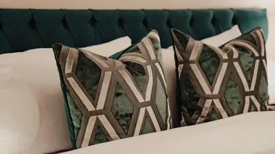 a group of pillows on a bed at Royal Chambers Serviced Apartments in Glasgow