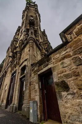 an old stone building with a door and a tower at Royal Chambers Serviced Apartments in Glasgow