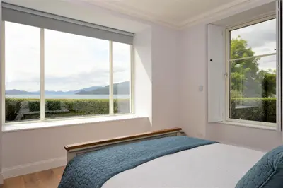a bedroom with a bed and a large window at Greenlea in Strachur