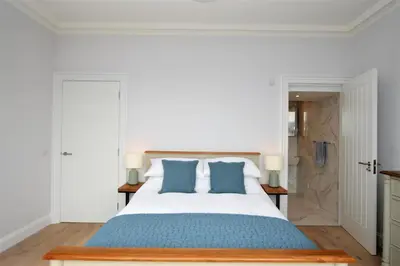 a bedroom with a large bed with blue pillows at Greenlea in Strachur