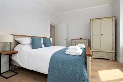 a bedroom with a large bed with a blue blanket at Greenlea in Strachur