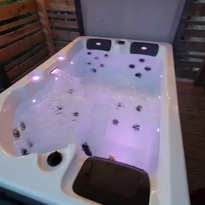 a white bath tub filled with water with insects in it at The Galloway Steading - The Stag Hoose family cabin with Hot Tub and Fire Pit in Glenluce