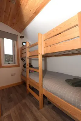 a bedroom with two bunk beds in a cabin at The Galloway Steading - The Stag Hoose family cabin with Hot Tub and Fire Pit in Glenluce