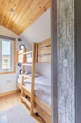 a bedroom with two bunk beds in a house at The Galloway Steading - The Stag Hoose family cabin with Hot Tub and Fire Pit in Glenluce