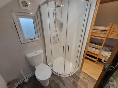a bathroom with a shower and a toilet at The Galloway Steading - The Stag Hoose family cabin with Hot Tub and Fire Pit in Glenluce