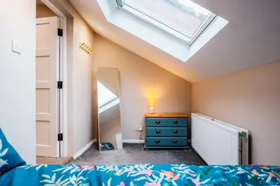 a bedroom with a skylight and a bed and a dresser at Dalmarnock Stay in Glasgow