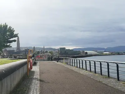 a walkway next to a fence next to a body of water at Central 1-Bed Apt Sleeps 4 5 mins to Station in Greenock