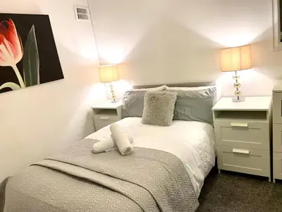 a small bedroom with a bed with two night stands at Central 1-Bed Apt Sleeps 4 5 mins to Station in Greenock