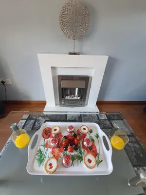 a plate of food on a table in front of a fireplace at PREMIER - Kenilworth House in Holytown