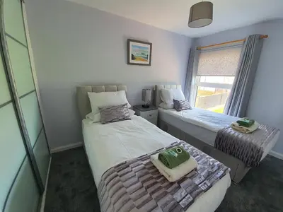 a bedroom with two beds and a window at PREMIER - Kenilworth House in Holytown