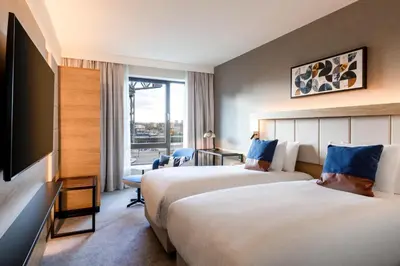 a hotel room with two beds and a flat screen tv at Courtyard by Marriott Glasgow SEC in Glasgow