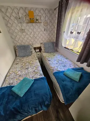 a small room with two beds and a window at Unique Caravan with Outdoor Space in Ballantrae
