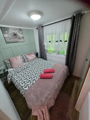 a bedroom with a bed with two red pillows on it at Unique Caravan with Outdoor Space in Ballantrae