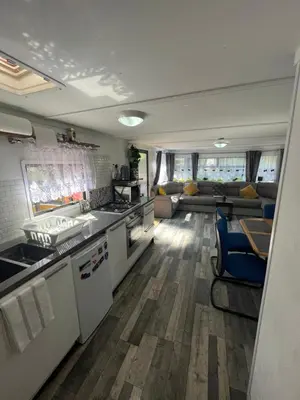 a kitchen and living room with a couch at Unique Caravan with Outdoor Space in Ballantrae
