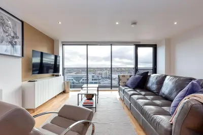 a living room with a couch and a large window at SECC Hydro Clyde View Apartment in Glasgow