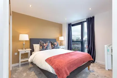 a bedroom with a bed and a large window at SECC Hydro Clyde View Apartment in Glasgow