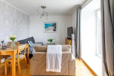 a living room with a couch and a table at Fresh, modern West End apartment beside Hydro in Glasgow