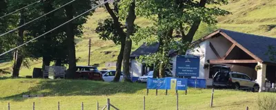 a building with cars parked in a field at 1-2 Dialknowe Holiday Cottage - Wanlockhead in Wanlockhead