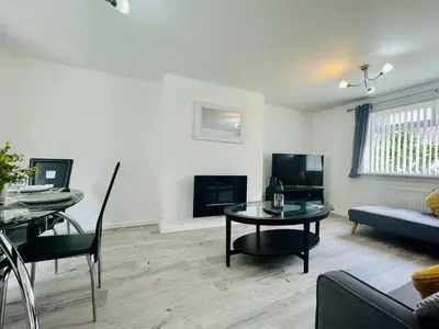 a living room with a table and a couch at Central Hamilton House in Hamilton