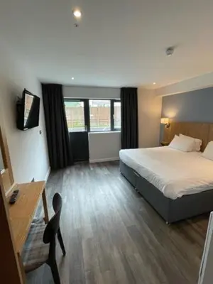 a hotel room with a bed and a desk at Loch Lomond Hotel in Balloch