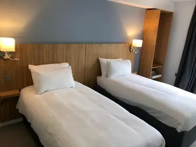 two beds sitting next to each other in a room at Loch Lomond Hotel in Balloch