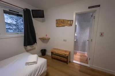 a bedroom with a bed and a window and a table at Roam West in Fort William