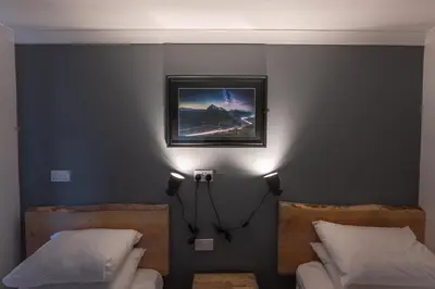 a bedroom with two beds and a picture on the wall at Roam West in Fort William