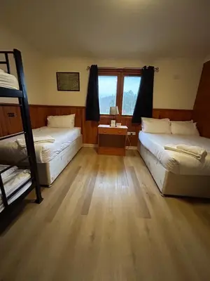 a bedroom with two bunk beds and a desk at Roam West in Fort William