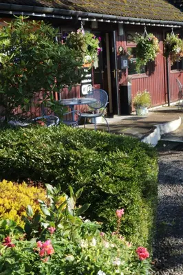 a garden with a table and chairs and flowers at Roam West in Fort William