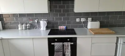 a kitchen with white cabinets and a counter top at Espedair Apartment in Paisley