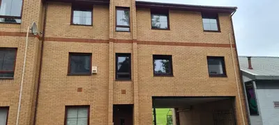 a brick building with windows on the side of it at Espedair Apartment in Paisley