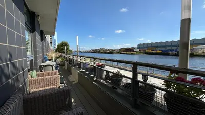 a balcony with a view of a river at Glasgow Harbour Clyde Waterfront Apartment in Glasgow