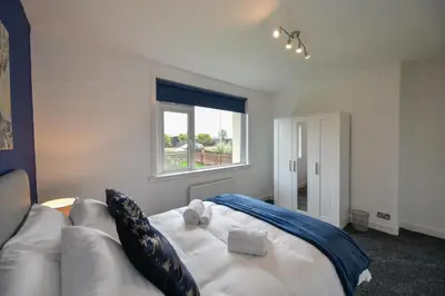 a living room with a white couch and a window at Greensleeves Place in Troon