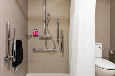 a bathroom with a shower stall with a toilet at Moxy Glasgow SEC in Glasgow