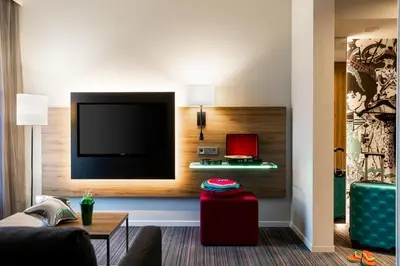 a living room with a flat screen tv on a wall at Moxy Glasgow SEC in Glasgow