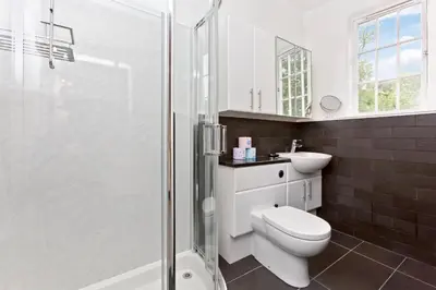 a bathroom with a toilet and a glass shower at Luxury-3-bedroom Ramsay Garden Apartment next to Edinburgh Castle in Edinburgh