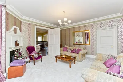 a living room with purple furniture and a fireplace at Luxury-3-bedroom Ramsay Garden Apartment next to Edinburgh Castle in Edinburgh