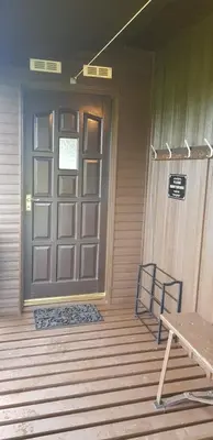 a front door of a house with a bench in front at Oakview Chalet in Glencoe