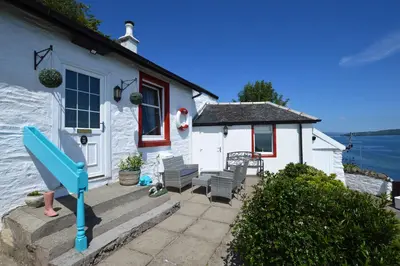 a white house with a blue slide in front of it at Arthur's Seat in Innellan