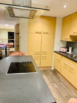 a kitchen with a stove top oven in a room at Glasgow City Centre G1 PENTHOUSE with RiverViews - Duplex - 4 Bedrooms, 3 Bathrooms, Kitchen, 1 Living room, 1 Dining room, 2 Terraces, Parking, Top Floor, 2050 sq ft, Merchant City in Glasgow