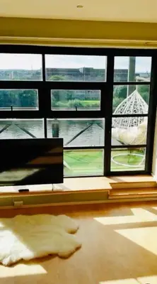 a room with a large window and a cat laying on the floor at Glasgow City Centre G1 PENTHOUSE with RiverViews - Duplex - 4 Bedrooms, 3 Bathrooms, Kitchen, 1 Living room, 1 Dining room, 2 Terraces, Parking, Top Floor, 2050 sq ft, Merchant City in Glasgow