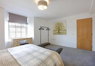 a bedroom with a bed and a tree on the wall at The Shandwick Place Residence No 2 in Edinburgh