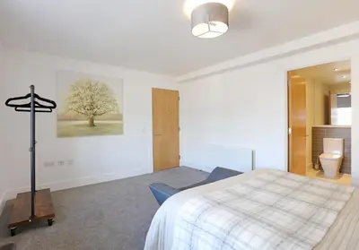 a bedroom with a bed and a tree on the wall at The Shandwick Place Residence No 2 in Edinburgh